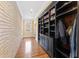 Hallway features hardwood floors, brick walls, built in shelves, and natural light from the window at the end at 6532 Wakefalls Dr, Wake Forest, NC 27587