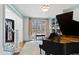 Cozy living room features a grand piano, built in shelves, and natural light from a large window at 6532 Wakefalls Dr, Wake Forest, NC 27587