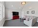 Bright living room with vaulted ceilings, black and white carpet, and modern entertainment center at 6532 Wakefalls Dr, Wake Forest, NC 27587