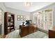 A spacious office with large windows, built in book shelves, and a large wooden desk at 6532 Wakefalls Dr, Wake Forest, NC 27587