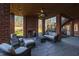 Relaxing outdoor patio featuring a fireplace, ceiling fan, brick columns, and comfortable seating at 6532 Wakefalls Dr, Wake Forest, NC 27587