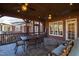 Covered patio featuring wood ceiling, stone floors, outdoor table and chairs, with view of home at 6532 Wakefalls Dr, Wake Forest, NC 27587