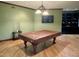 This recreation room features green walls, wood floors, and a pool table covered with a brown tarp at 6532 Wakefalls Dr, Wake Forest, NC 27587