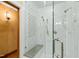 This marble tiled shower features glass doors, a shower bench and a rainfall shower head at 6532 Wakefalls Dr, Wake Forest, NC 27587