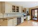 Wet bar featuring custom cabinets, stone backsplash, wine refrigerator, and outdoor access at 6532 Wakefalls Dr, Wake Forest, NC 27587