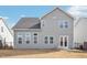 Back exterior of a two-story home featuring vinyl siding, well-manicured lawn, and a black metal fence at 730 Tibumoll Ln, Fuquay Varina, NC 27526