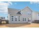 Rear view of a two-story home featuring gray vinyl siding, manicured lawn, and a black metal fence at 730 Tibumoll Ln, Fuquay Varina, NC 27526