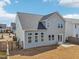 Back of gray home featuring a fenced yard, patio, and lots of windows at 730 Tibumoll Ln, Fuquay Varina, NC 27526
