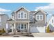 Charming two-story home with beautiful gray wood and stone accents and a welcoming front porch at 730 Tibumoll Ln, Fuquay Varina, NC 27526