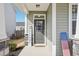 Close up of a stylish gray front door with decorative welcome sign on a covered porch at 730 Tibumoll Ln, Fuquay Varina, NC 27526