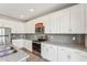 Well-lit kitchen with white cabinets, stainless steel appliances, and grey backsplash at 730 Tibumoll Ln, Fuquay Varina, NC 27526