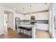 Bright kitchen with large island, barstool seating, stainless steel appliances, and light wood floors at 730 Tibumoll Ln, Fuquay Varina, NC 27526