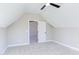 Attic bedroom with neutral carpet, bright window, a ceiling fan, and an open doorway to another room at 75 Harvest View Way, Franklinton, NC 27525