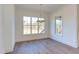 Bright dining room featuring hardwood floors, a modern light fixture, and large windows offering scenic views at 75 Harvest View Way, Franklinton, NC 27525