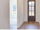 Bright entryway with a hardwood floor and a stylish, paneled front door leading into a carpeted bedroom at 75 Harvest View Way, Franklinton, NC 27525