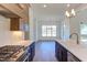Bright kitchen showcasing stainless steel appliances, wooden cabinets, and a view to the adjacent dining area at 75 Harvest View Way, Franklinton, NC 27525