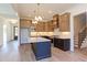 Open kitchen with an island, custom cabinets, stainless appliances, and an adjacent staircase at 75 Harvest View Way, Franklinton, NC 27525