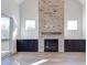 Bright living room with a stone fireplace, built-in cabinets, and sliding glass doors leading to a porch at 75 Harvest View Way, Franklinton, NC 27525