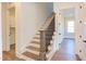 Elegant staircase with hardwood steps and a dark metal railing leading to the second floor at 75 Harvest View Way, Franklinton, NC 27525