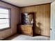Bedroom featuring paneled walls, window, and an antique dresser with a mirror at 750 David St, Henderson, NC 27536