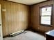 Empty bedroom featuring wood paneled walls and a window at 750 David St, Henderson, NC 27536