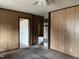 Unfurnished living room with wood paneled walls, ceiling fan, and doorway to adjacent room at 750 David St, Henderson, NC 27536