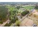 Aerial view of sprawling wooded property with updated homes and freshly tilled land at 7722 Nc 27 W, Lillington, NC 27546