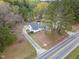 Aerial view of a charming home with a long driveway and lush landscaping surrounded by mature trees at 7722 Nc 27 W, Lillington, NC 27546