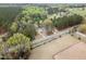 Aerial view of a home with extensive acreage, featuring mature trees and a partially fenced pasture at 7722 Nc 27 W, Lillington, NC 27546