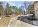 A huge backyard with a concrete slab and an array of playground toys and trees at 7722 Nc 27 W, Lillington, NC 27546