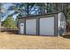 Large two-car garage with modern roll up doors, and diamond accent window at 7722 Nc 27 W, Lillington, NC 27546