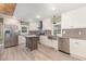 Bright kitchen featuring white cabinets, stainless steel appliances, and a center island with stylish gray wood flooring at 7722 Nc 27 W, Lillington, NC 27546