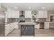 Bright kitchen featuring white cabinets, stainless steel appliances, island and stylish gray wood flooring at 7722 Nc 27 W, Lillington, NC 27546