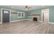 Spacious living room featuring stylish gray wood flooring, fireplace, and calming light green walls at 7722 Nc 27 W, Lillington, NC 27546