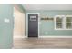 Inviting living room with stylish gray wood flooring, front door, and calming light green walls at 7722 Nc 27 W, Lillington, NC 27546