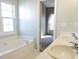 This bathroom features a bathtub, double sink vanity, a view into a bedroom, and a large window at 8 Weeping Beech Way, Durham, NC 27713