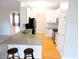 Charming kitchen featuring white cabinets, stainless steel appliances, breakfast bar and hardwood floors at 8 Weeping Beech Way, Durham, NC 27713