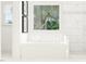 Bright white bathroom featuring a soaking tub under a large window and a glass shower at 917 Thimbleweed Way, Wake Forest, NC 27587
