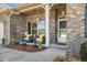 Inviting front porch with cozy seating, decorative plants, and a beautifully adorned front door at 99 Preserve Dr, Benson, NC 27504