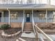 Close up of the front entrance featuring brick stairs, a blue door, and a cozy porch at 1002 Walker Field Dr, Rougemont, NC 27572