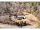 An aerial view of a house featuring mature trees surrounding it and several outbuildings in the spacious yard at 10611 Quail Roost Rd, Bahama, NC 27503