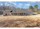 An exterior rear view of a house featuring an enclosed porch and a spacious backyard at 10611 Quail Roost Rd, Bahama, NC 27503