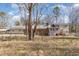 Fenced-in backyard with a view of the house's additions and mature trees providing privacy at 10611 Quail Roost Rd, Bahama, NC 27503