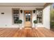 Close-up of the front door framed by windows and potted plants on a wood porch at 114 W Lynch St, Durham, NC 27701