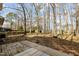 Spacious backyard with mature trees, wooden deck, and partial fencing at 1195 Champion Dr, Cary, NC 27511