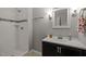 Bathroom with white subway tiled shower and dark vanity with a white countertop at 1195 Champion Dr, Cary, NC 27511