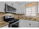 Kitchen featuring stainless steel appliances, white cabinets and granite countertops at 1195 Champion Dr, Cary, NC 27511