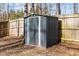 Outdoor shot of a storage shed with a closed door in the fenced-in backyard at 1195 Champion Dr, Cary, NC 27511