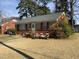 Cozy one-story house featuring a stone facade with red shutters, a well-maintained lawn, and a welcoming entrance at 1218 W Pearsall St, Dunn, NC 28334