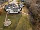 Expansive estate featuring a luxurious white home, an outdoor firepit and lush greenery at 1326 Lochshire Dr, Burlington, NC 27215